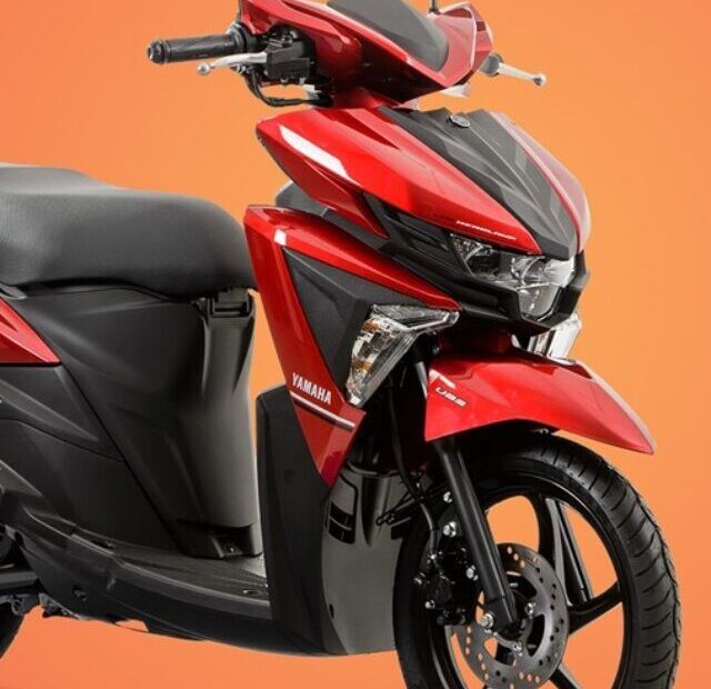 Yamaha NEO vermelha em fundo laranja.