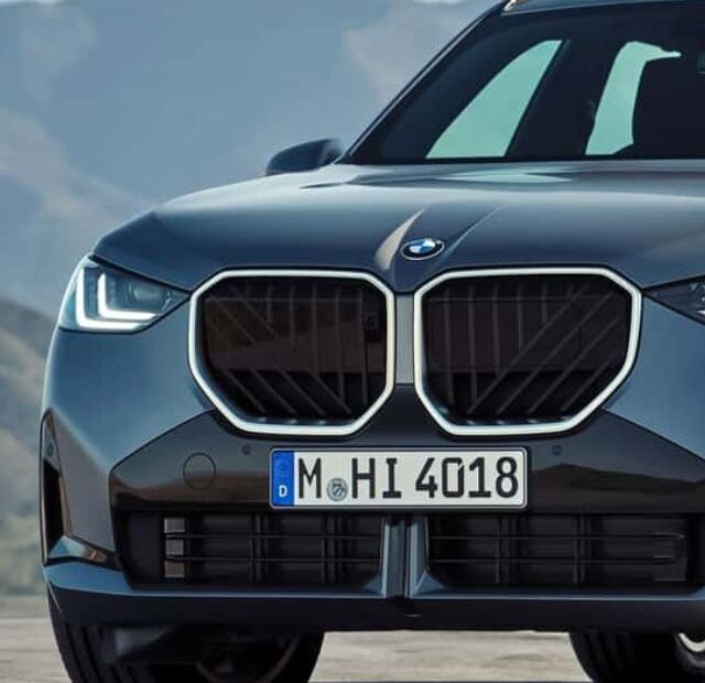 BMW X3 cinza parada na diagonal.