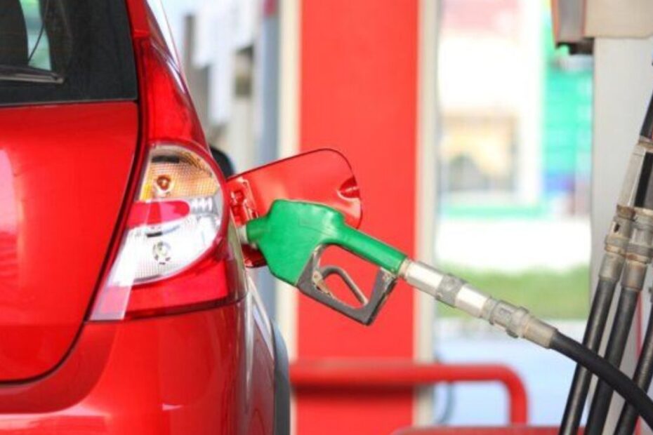 Carro vermelho abastecendo em posto.