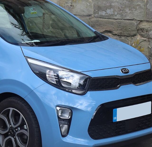 Kia Picanto azul parado na diagonal.