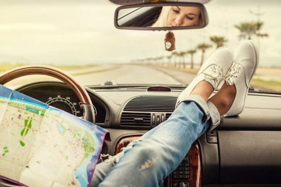 Mulher olhando mapa dentro de carro.