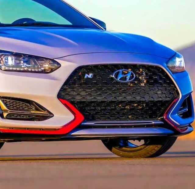 Hyundai Veloster prata parado na diagonal.