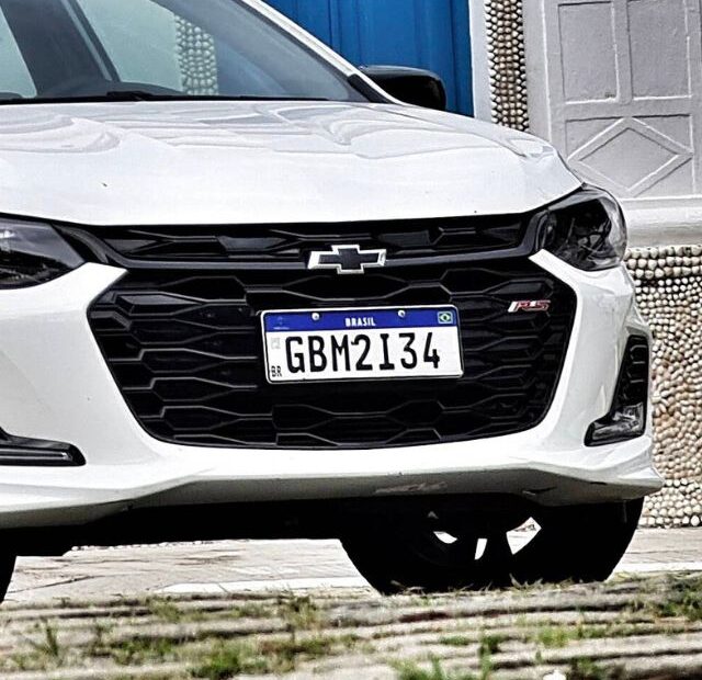 Onix RS branco parado na diagonal.