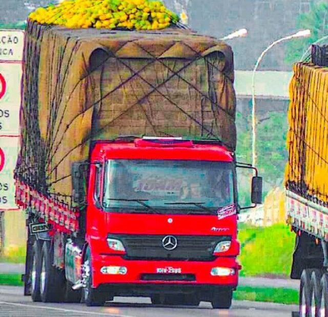 Caminhão arqueado vermelho em velocidade.