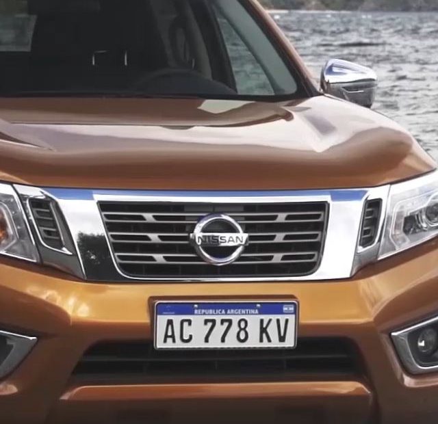 Nissan laranja parado de frente.