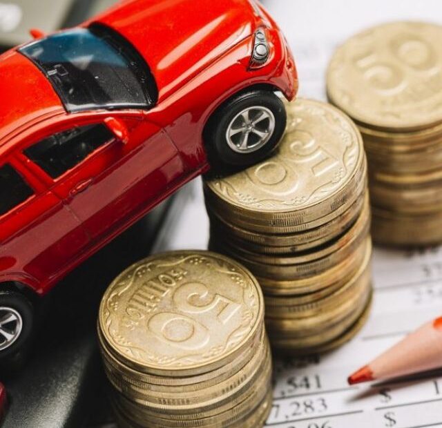 Carrinho de brinquedo em cima de moedas.