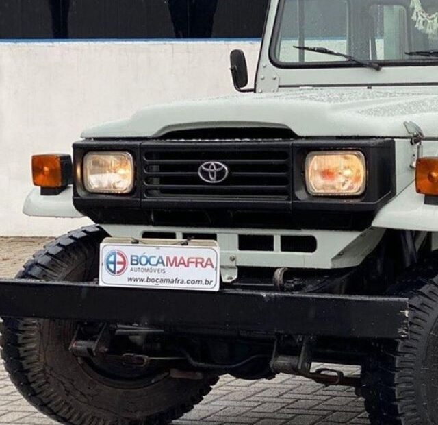 Toyota Bandeirante branca parada na diagonal.