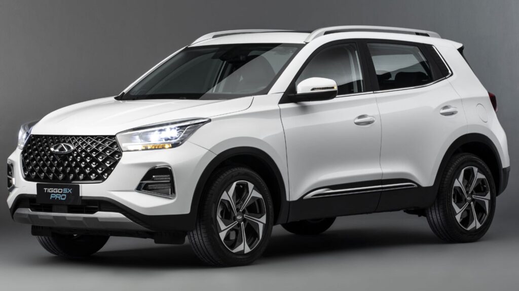 Caoa Chery Tiggo 5 branco na diagonal em um fundo cinza.
