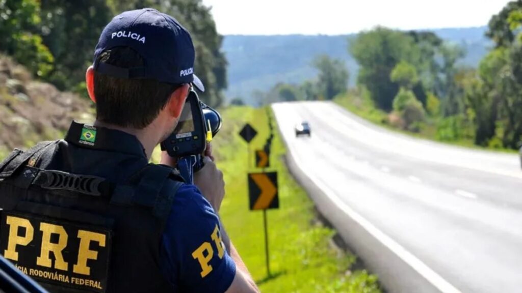 Policial com o radar móvel marcando Excesso de Velocidade.