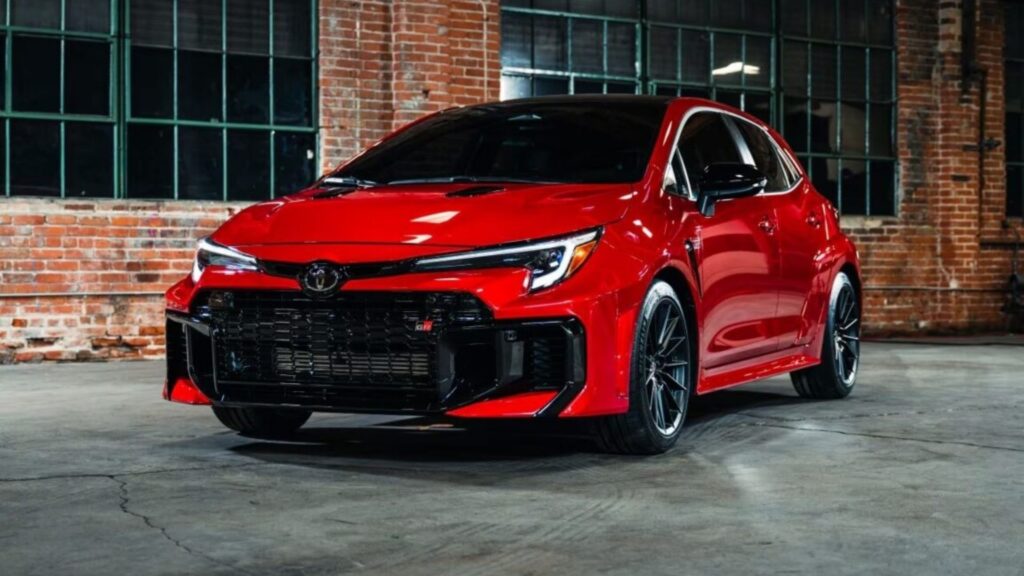 GR Corolla 2025 vermelho parado na diagonal com os faróis ligados.