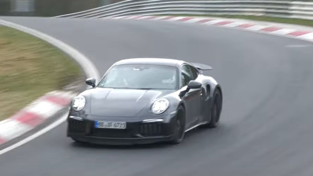 Porsche 911 Turbo 2026 preta na pista de corrida.