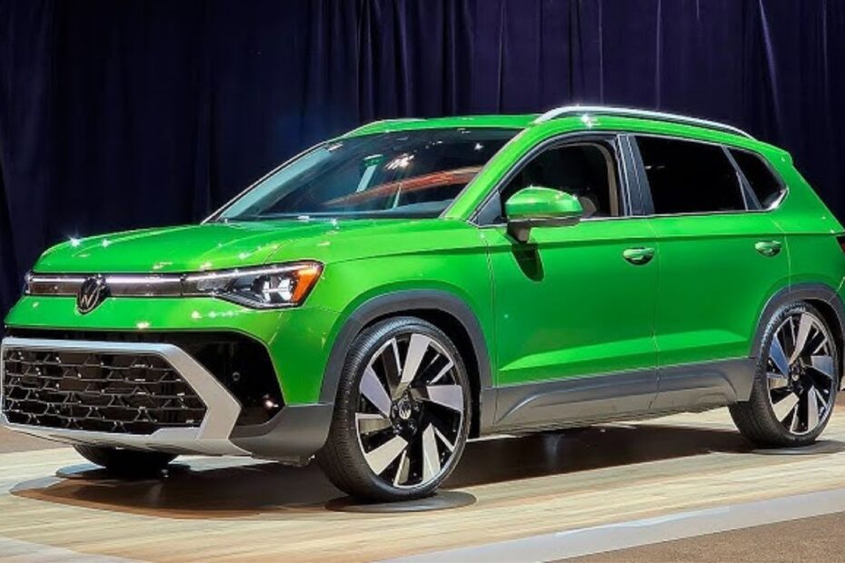 Volkswagen Taos verde parado na diagonal em uma exposição.