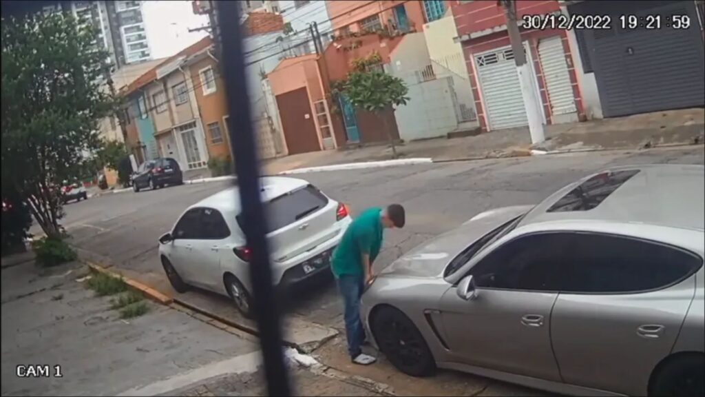 Homem roubando um farol de um carro.