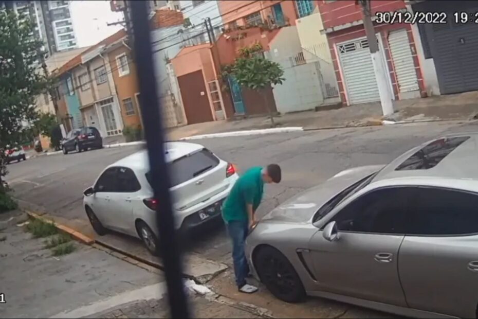 Homem roubando um farol de um carro.
