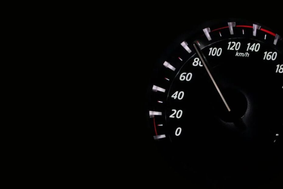 Velocímetro de carro em fundo preto.
