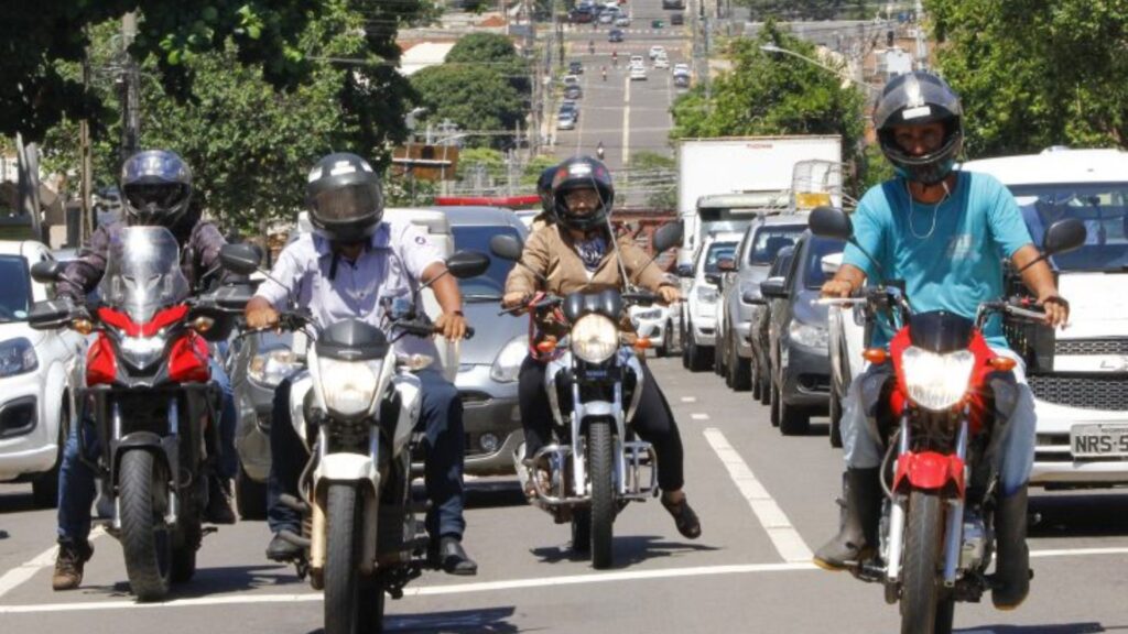 Motos na estrada esperando o semáforo abrir para ir pagar o  IPVA.
