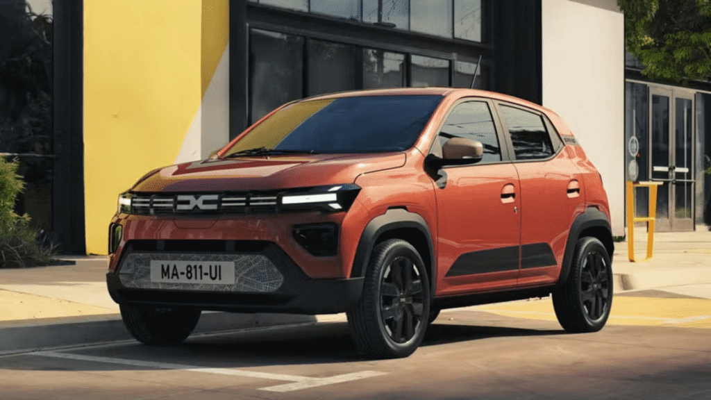 Novo Kwid E-Tech laranja parado na diagonal.