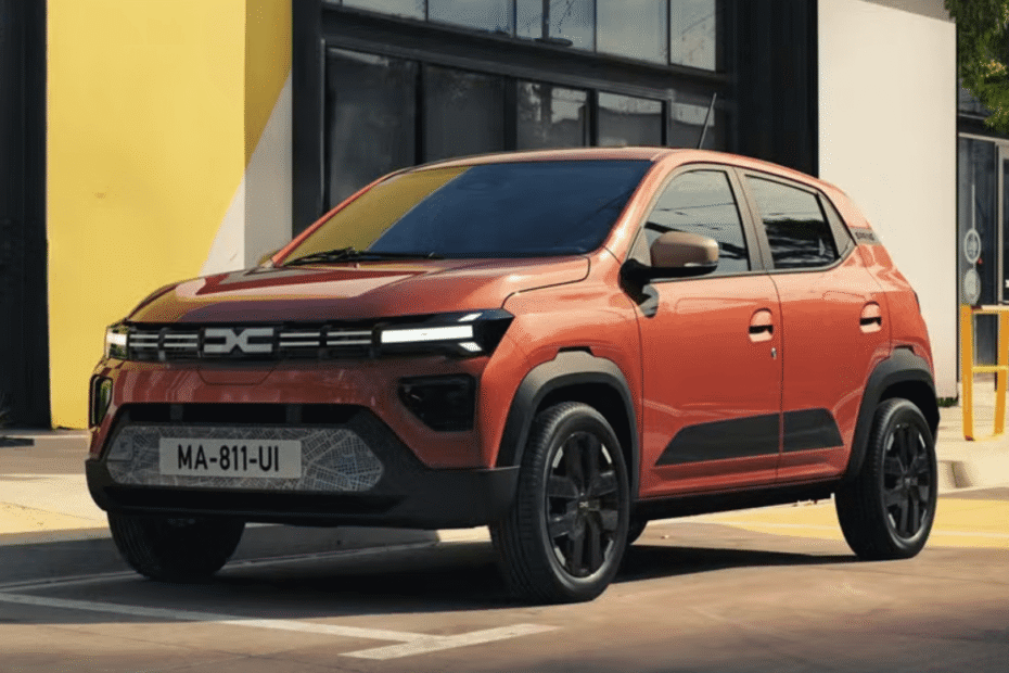 Novo Kwid E-Tech laranja parado na diagonal.