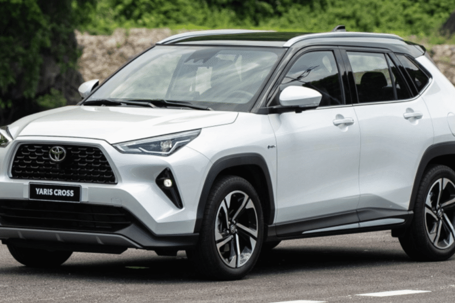 Toyota Yaris Cross branco parado na diagonal no meio de um asfalto.