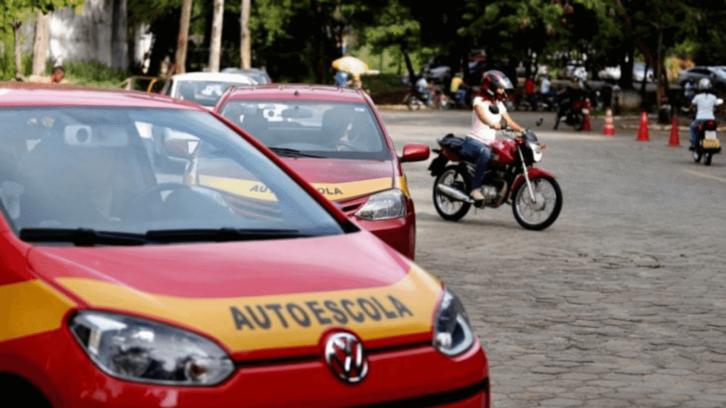 Carros da autoescola e uma moto.