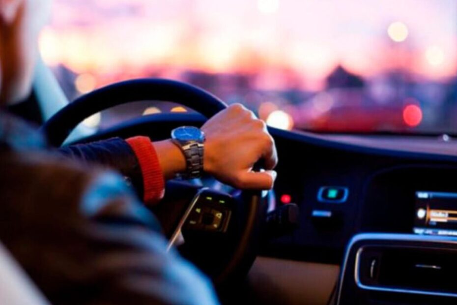pessoa segurando o volante com uma mão.