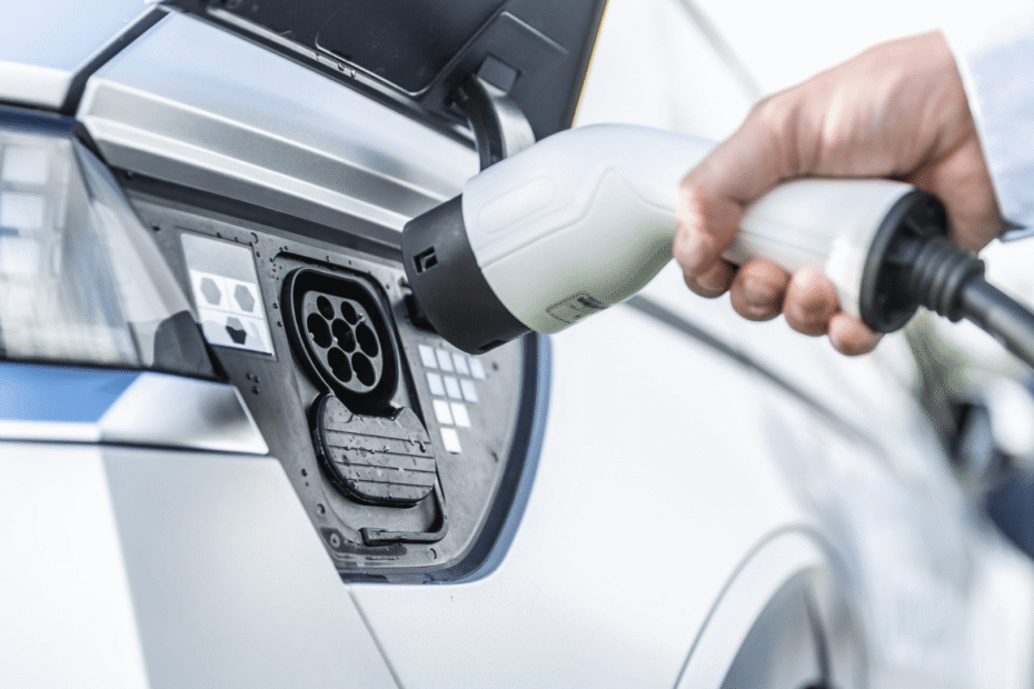 Pessoa colocando o seu carro elétrico a carregar.